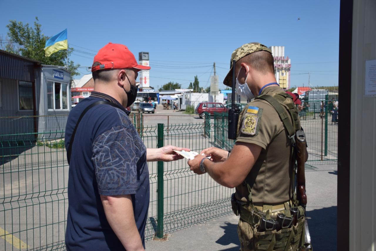 прикордонник та чоловік на КПВВ Станиця Луганська в Луганській області