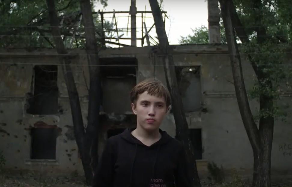подросток возле разбомбленного дома в Торецке