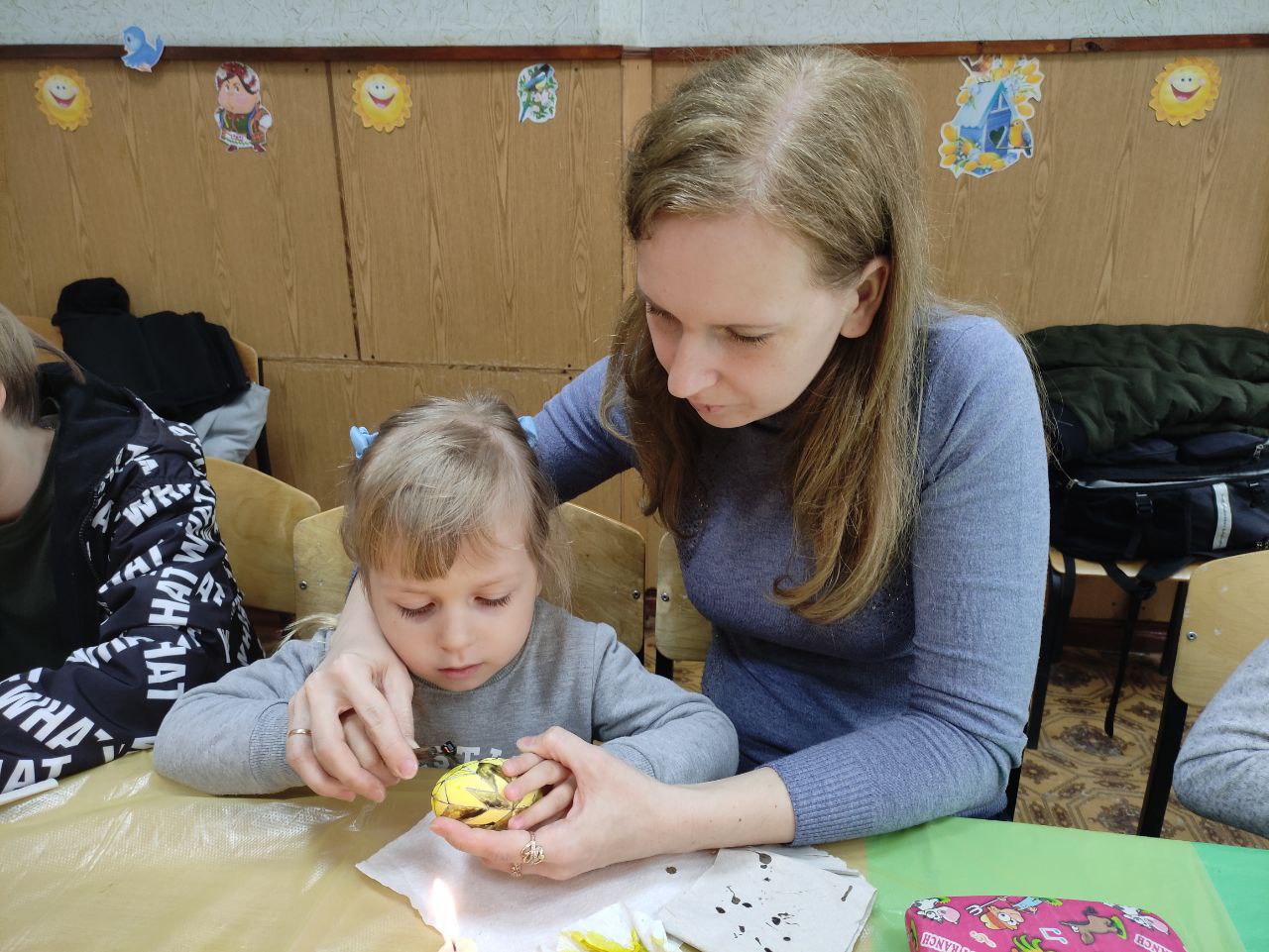 ребенок с мамой расписывает писанку в Донецкой области