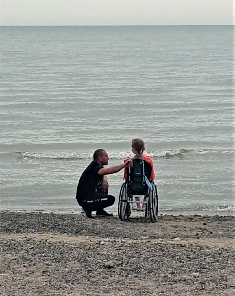 девочка в инвалидном кресле на берегу моря