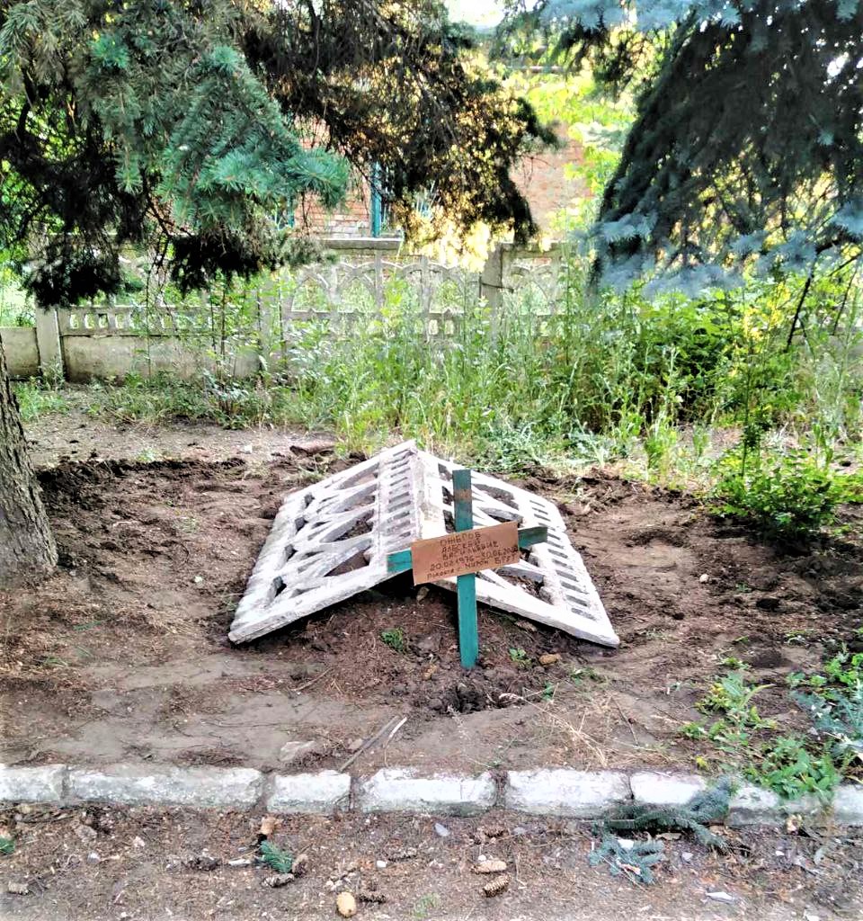могила местного жителя в газоне в Северске