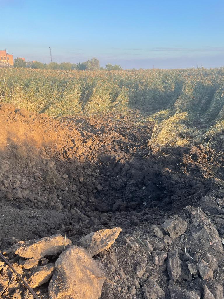 воронка в поле возле места обстрела в Донецкой области