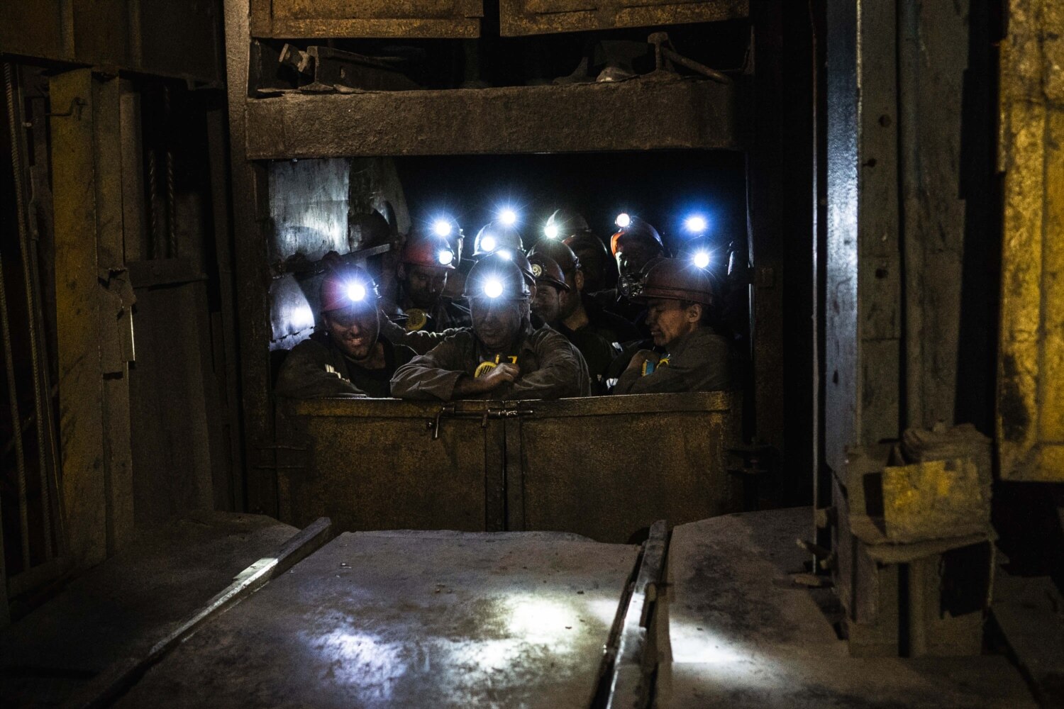 шахтеры в клети в угольной шахте