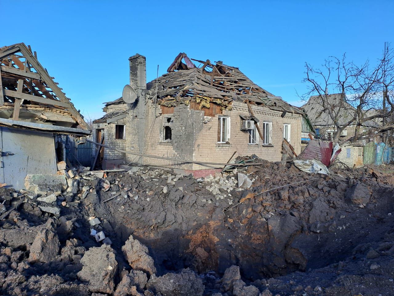 зруйнований приватний будинок та вирва від обстрілу РФ у Донецькій області