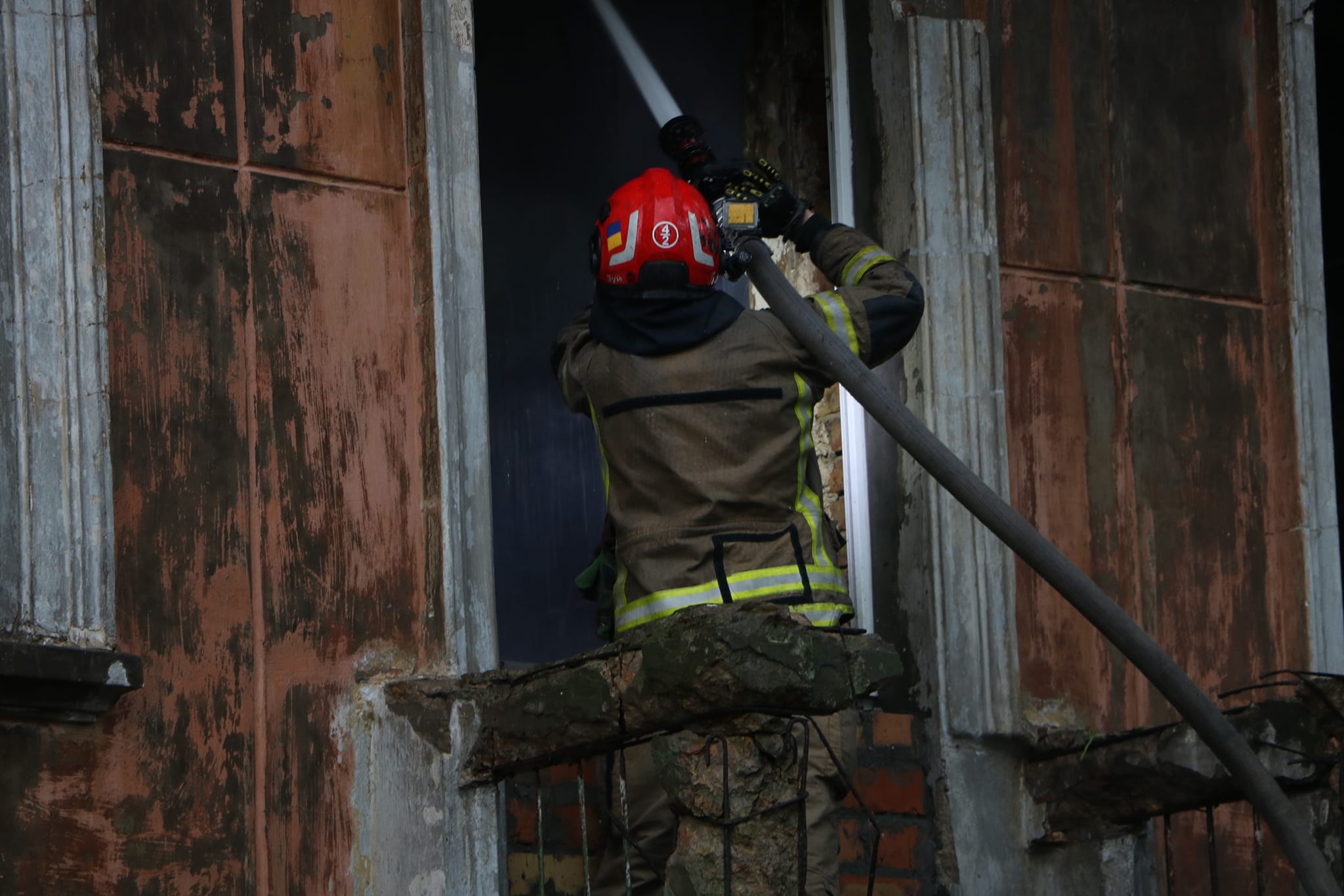 рятувальник гасить пожежу в розбомбленій квартирі