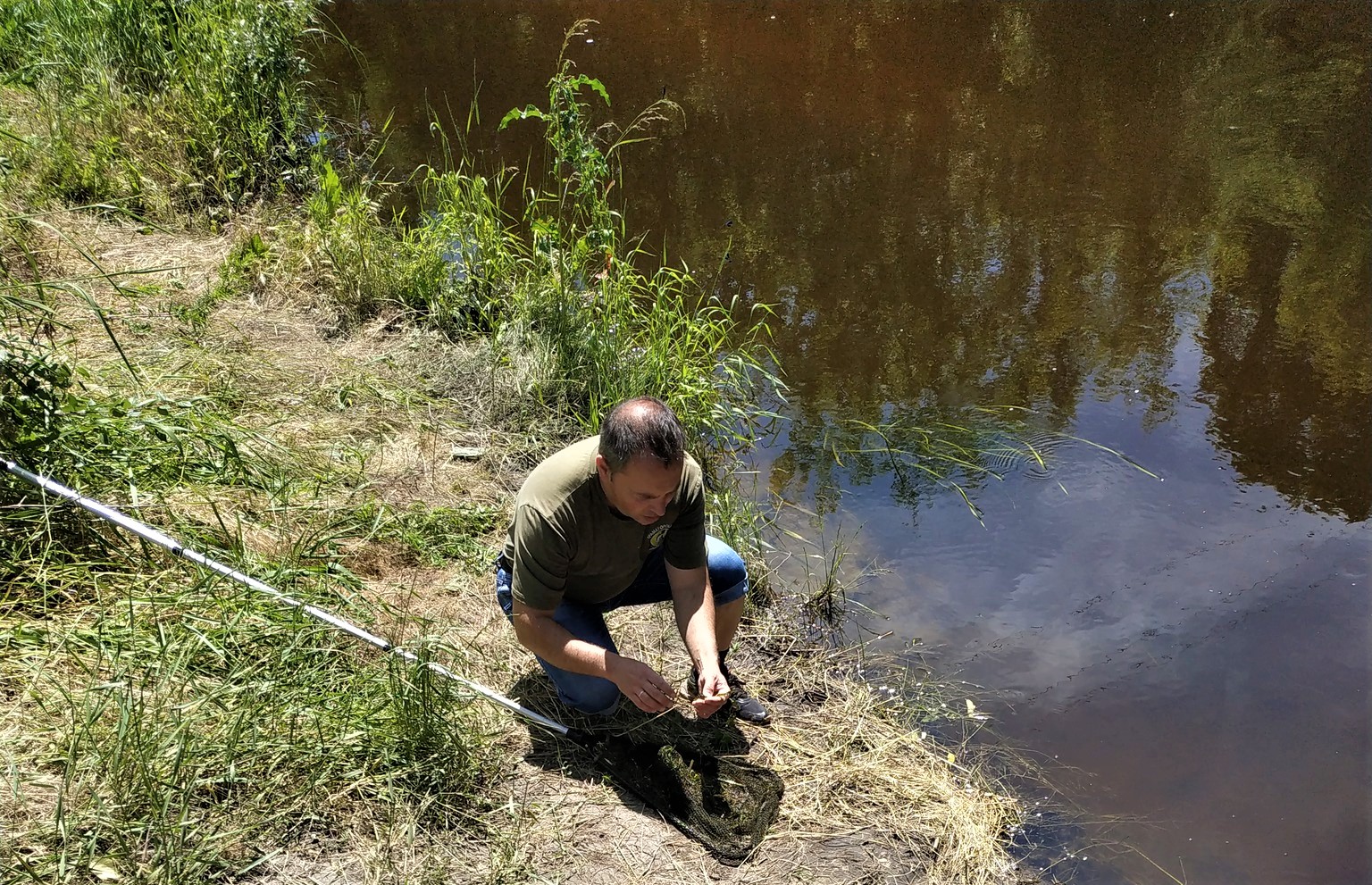 працівник обстежує ріку Сухий Торець в Донецькій області