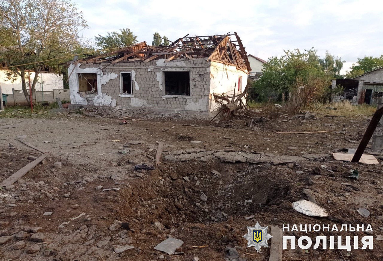 Воронка и поврежденный 10 июля дом в Донецкой области