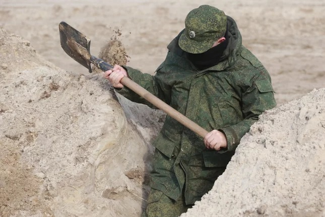 Облаштування позицій росіян, солдат риє окоп, де можна укритись бій час боїв