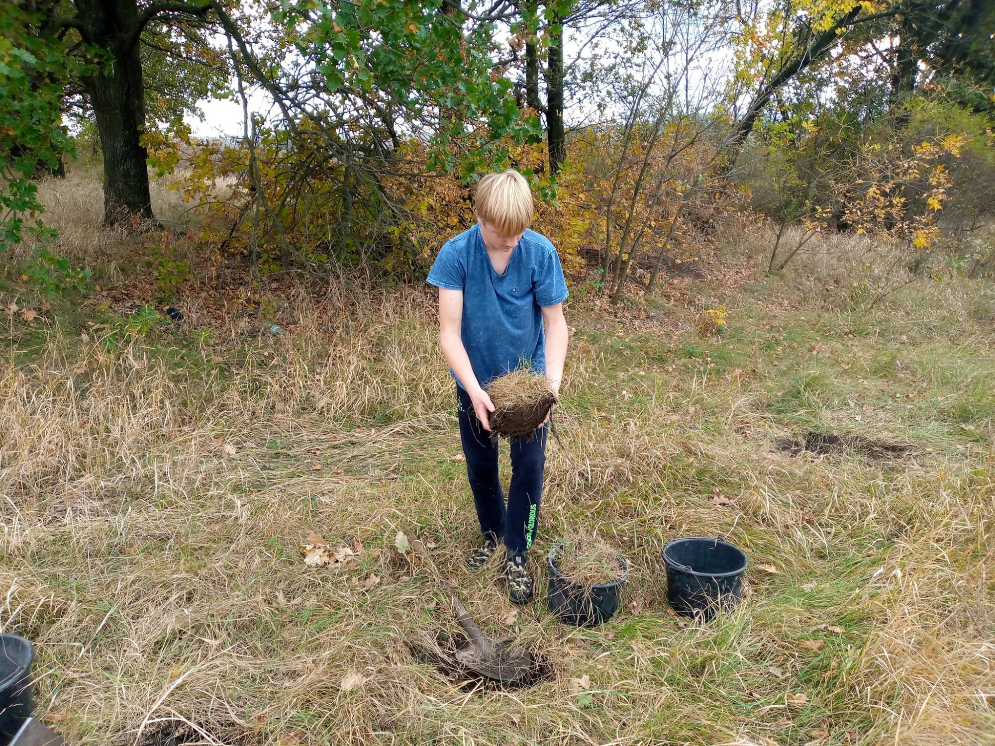 хлопець вирізав дернину з травою з землі у Донецькій області
