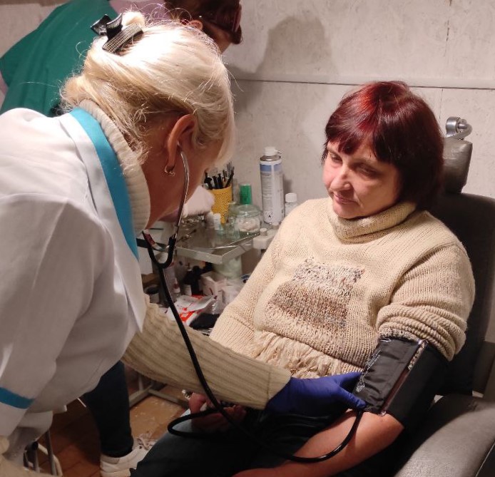 медсестра вимірює тиск пацієнтці у Донецькій області
