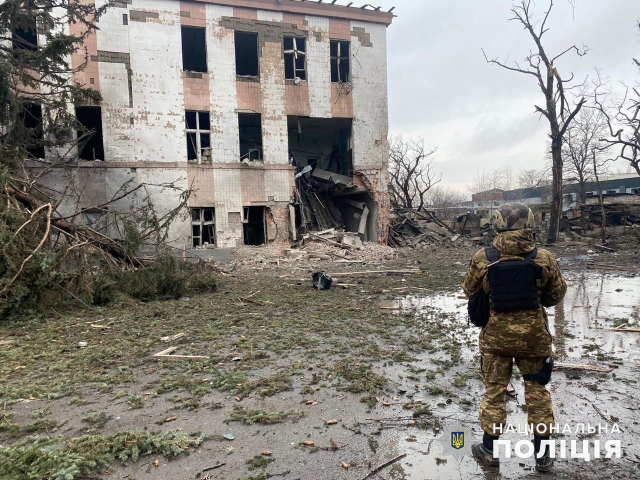 Полицейский рядом с разрушенным зданием в Донецкой области