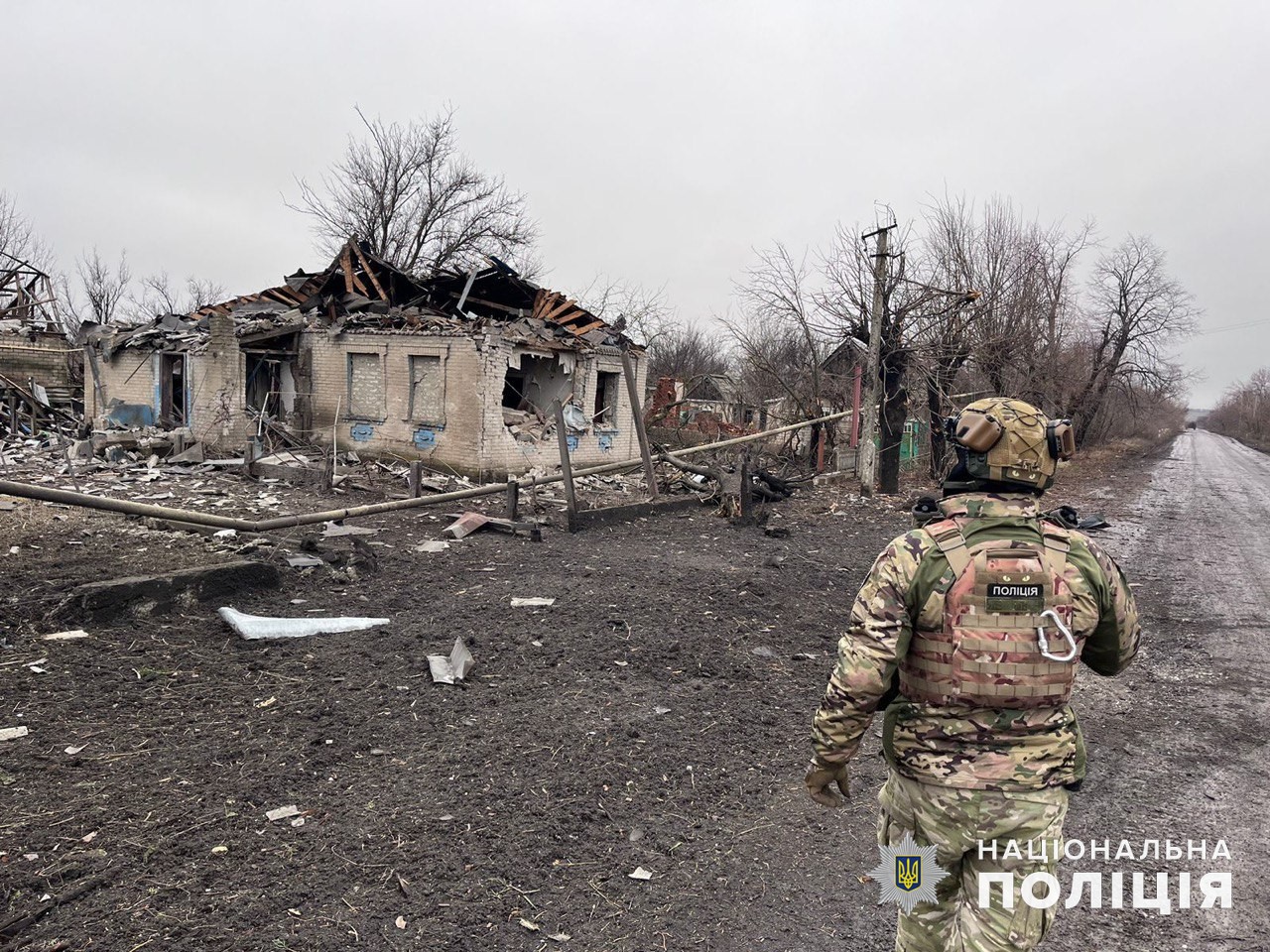 Поліцейський поряд зі зруйнованим обстрілами російських окупантів приватним будинком.