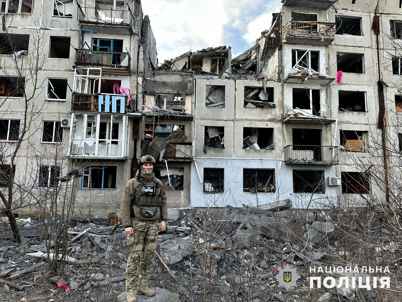Поліцейський на фоні зруйнованого будинку на Донеччині