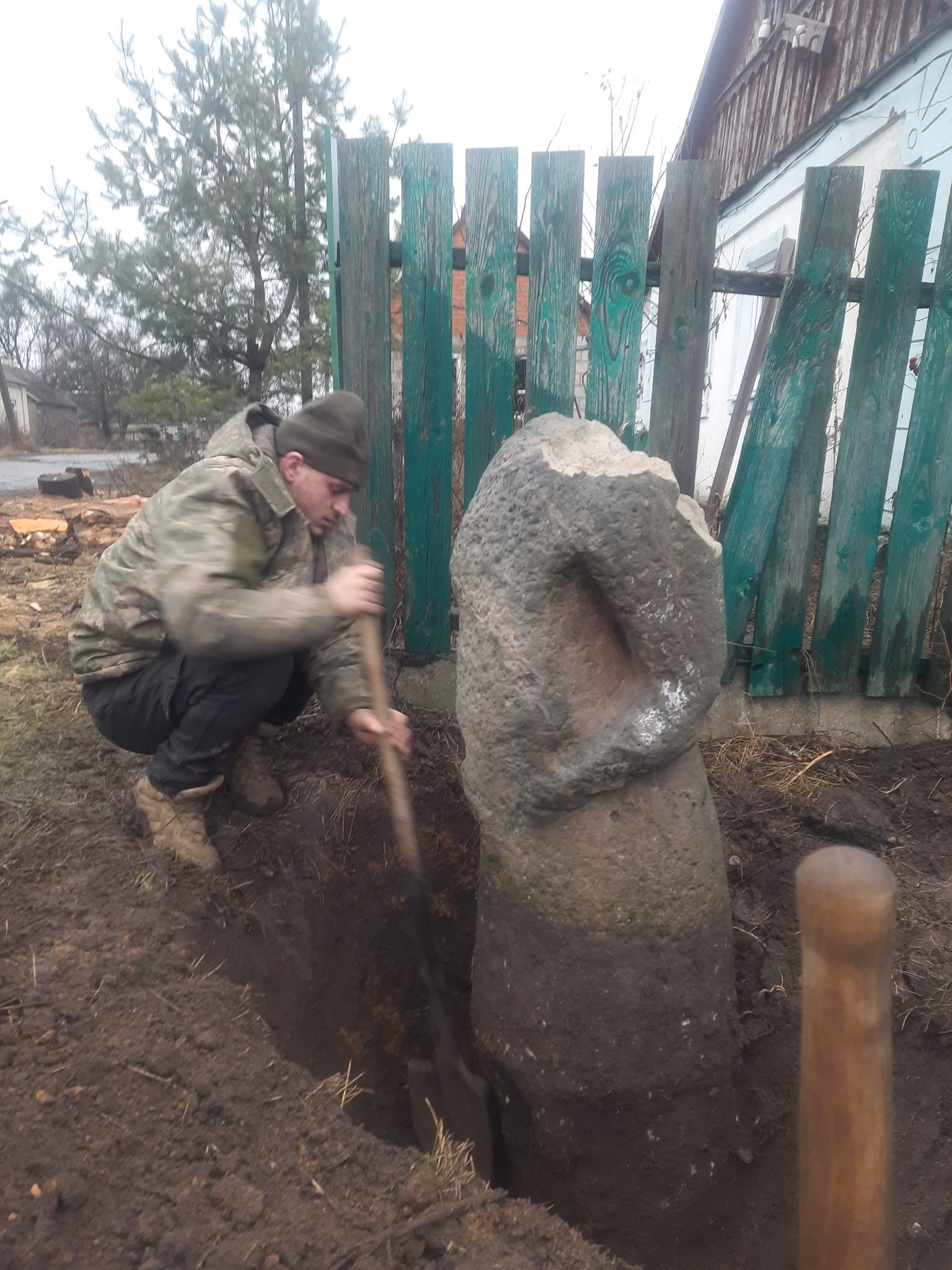 Військовослужбовець викопує кам'яну бабу у Великій Новосілці