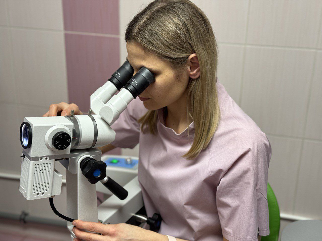 Лікарка з Бахмута дивиться у мікроскоп
