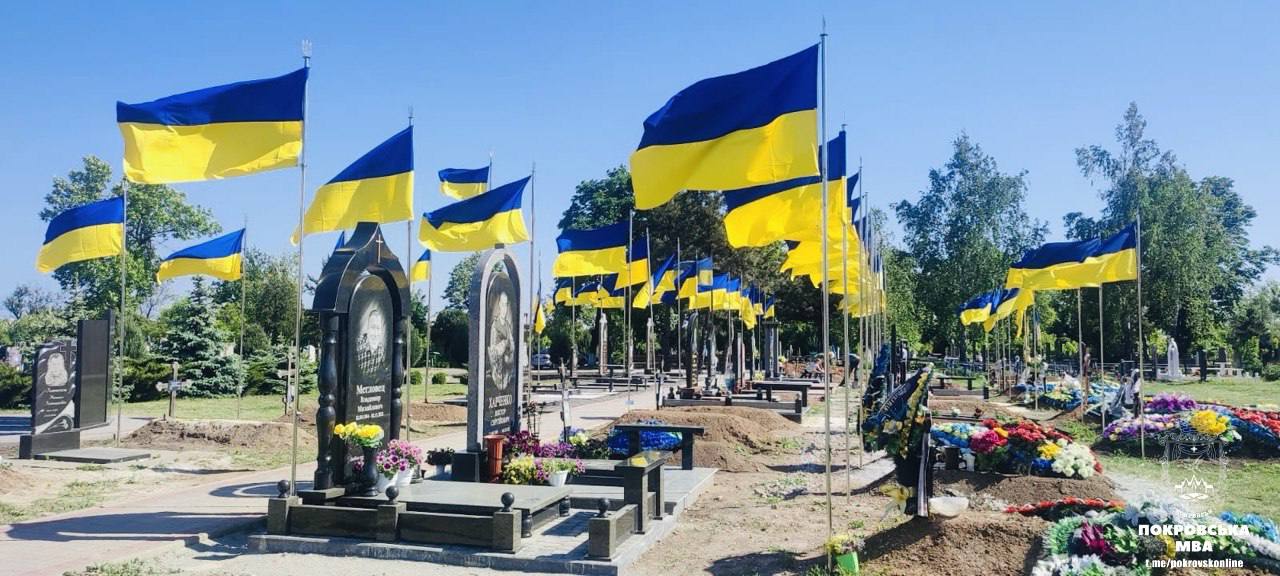 Нові прапори біля могил військових у Покровській громаді. Фото: Покровська МВА