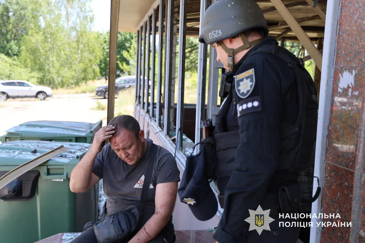 A man in a police uniform is sitting on a bench.