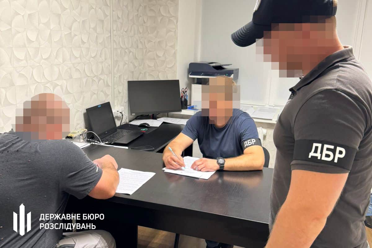 Підозрюваний офіцер поряд із слідчими.