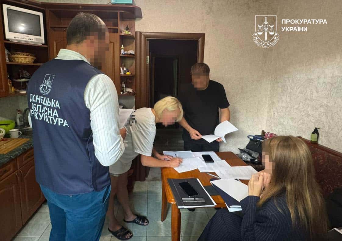 Фігурантка справи поряд зі слідчими. Фото: Донецька обласна прокуратура
