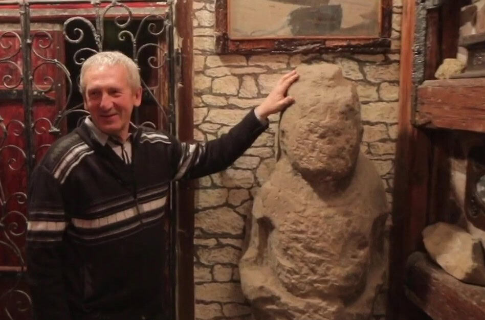 В’ячеслав Долженко з кам’яною бабою у власному музеї. Скриншот Вільного Радіо з відео “Орел і Решка”